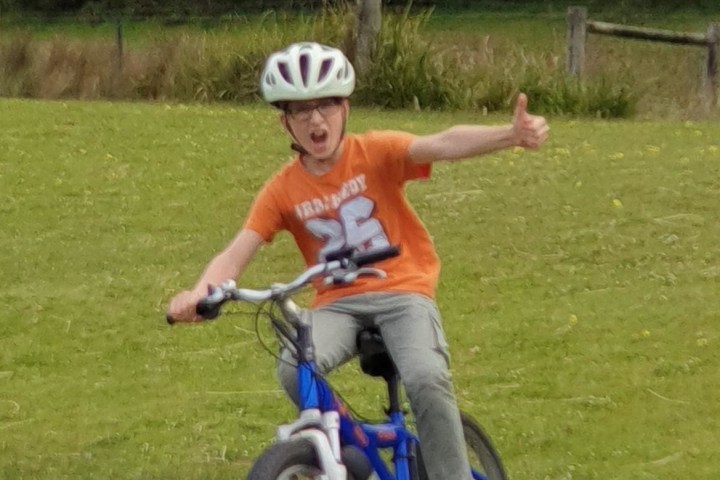 Young boy thumbs up while riding e bikes